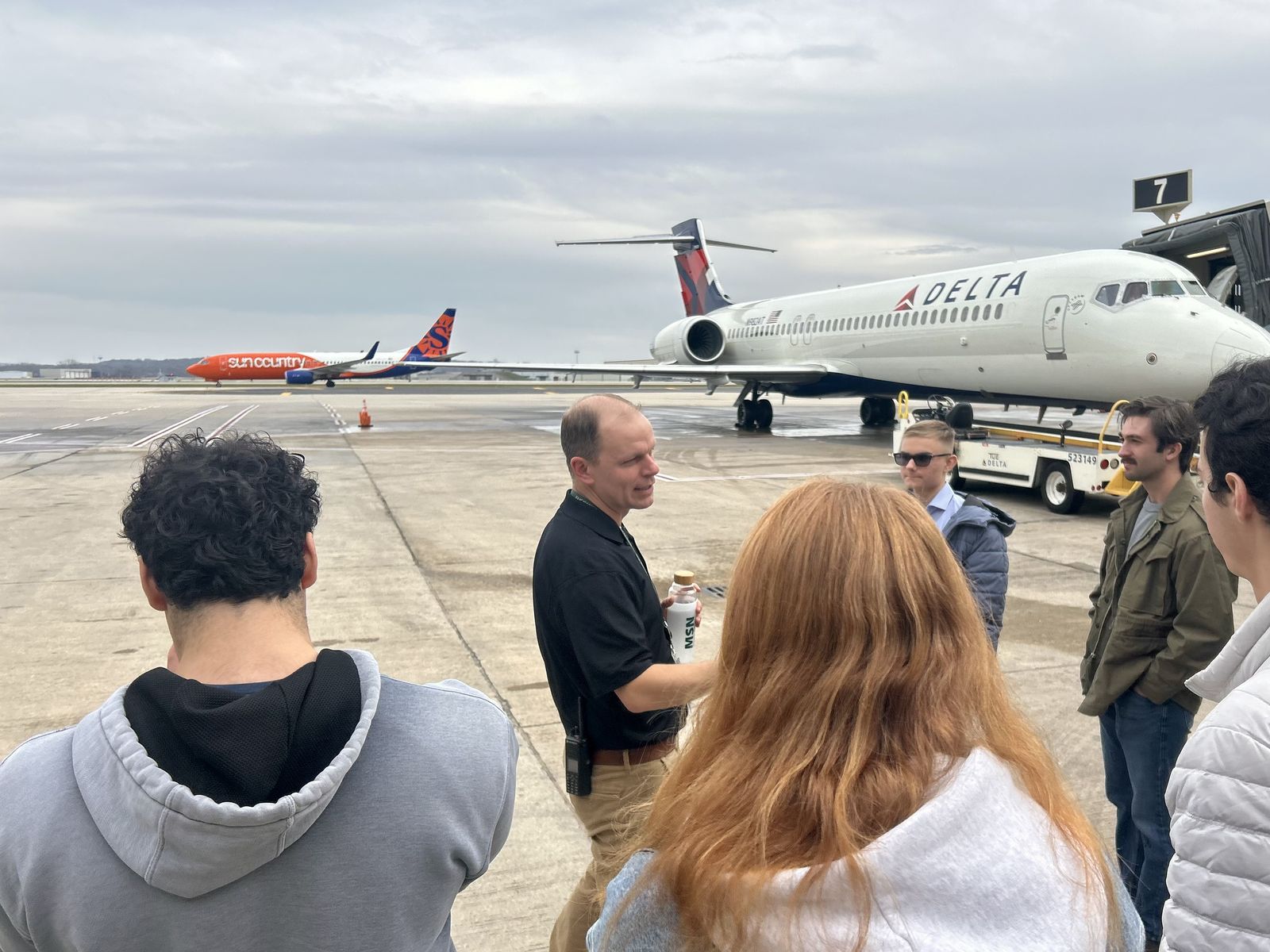 Members listen to a guide on the ramp at Dane County Regional Airport