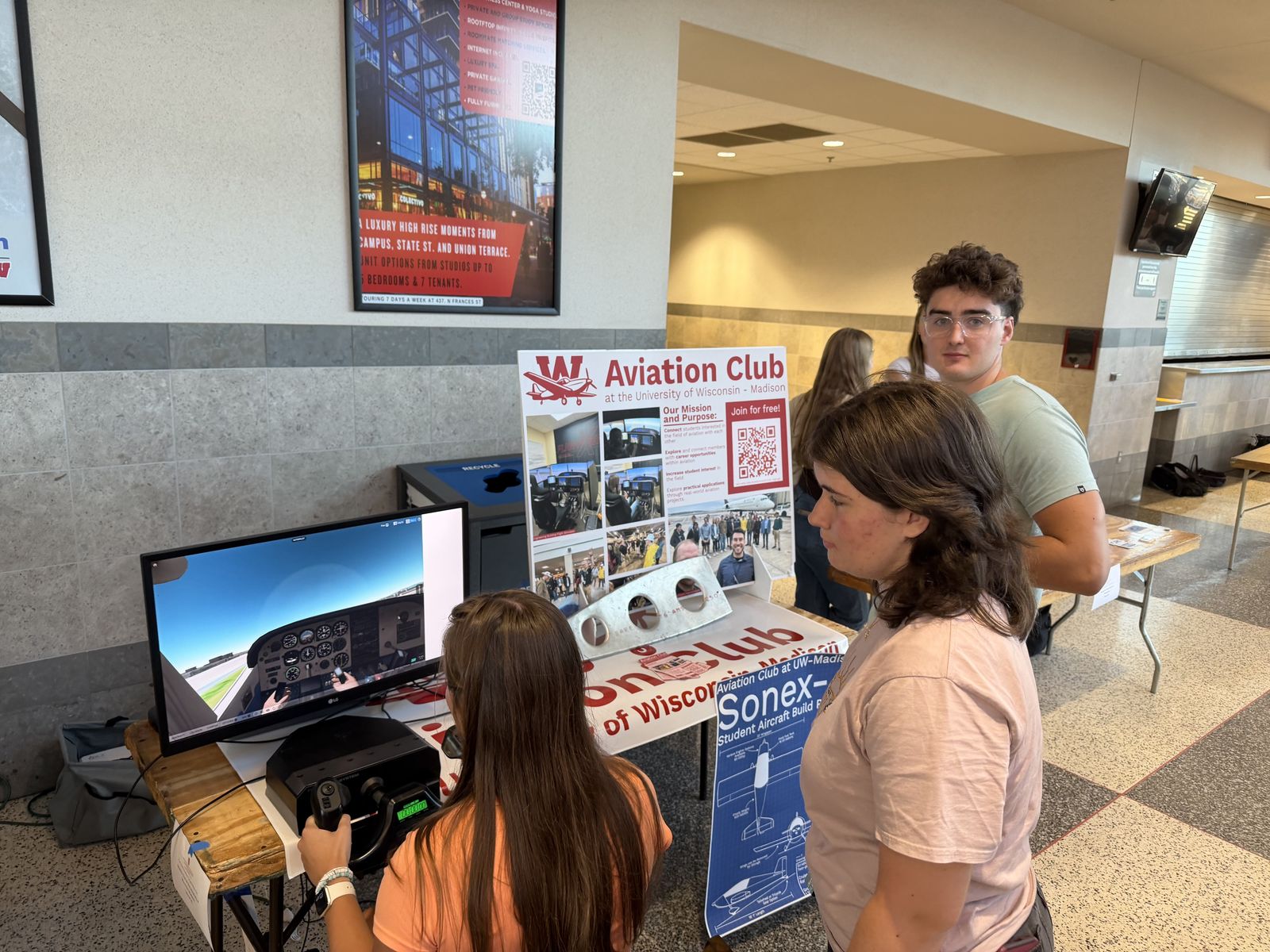 The Aviation Club booth at the student org fair, with the flight simulator and a Sonex wing rib on display