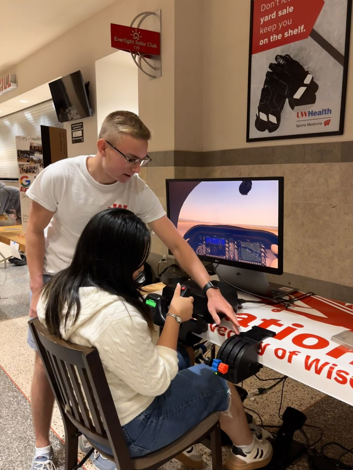 A student tries the club flight simulator at the student org fair booth