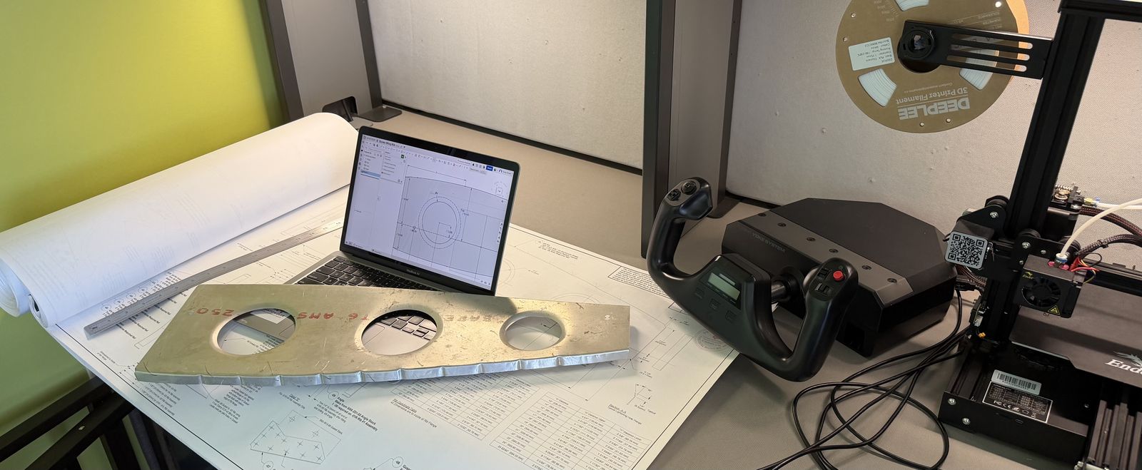Sonex wing rib on top of the original paper plans, next to a laptop showing the CAD model